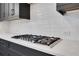 Close up of kitchen counter with stainless steel gas range and modern white subway tile backsplash at 2239 Chestnut Pass, Decatur, GA 30033