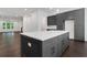 Spacious kitchen with large island, gray cabinets, stainless appliances, hardwood floors, and open layout to living area at 2239 Chestnut Pass, Decatur, GA 30033