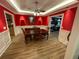 Well-lit formal dining room showing a red-accent wall, wainscoting, and views of adjacent rooms at 828 Cedar Stream Ct, Loganville, GA 30052