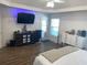 Open main bedroom features wood-look flooring, a door to the patio, a ceiling fan, and abundant natural light at 828 Cedar Stream Ct, Loganville, GA 30052