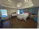 Spacious main bedroom with a tray ceiling, wood-look floors, and abundant natural light from the large windows at 828 Cedar Stream Ct, Loganville, GA 30052