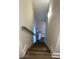 Well lit staircase with wood stairs and white risers leading to lower level at 828 Cedar Stream Ct, Loganville, GA 30052