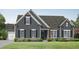 Charming single-story home with gray siding, black shutters, brick accents, and well-manicured landscaping at 1239 Pj East Rd, Covington, GA 30014