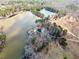 A high angle view of the property, nestled among mature trees, with private dock, and waterfront views at 1401 Rainey Rd, Temple, GA 30179