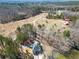 Stunning aerial view of a lakeside property with a home nestled among trees and distant outbuildings at 1401 Rainey Rd, Temple, GA 30179
