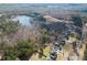 An aerial view showcasing the property's waterfront location, nestled among trees, with nearby residential areas at 1401 Rainey Rd, Temple, GA 30179