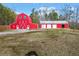 Vibrant red barn with white accents, offering ample storage and rustic charm to the property at 1401 Rainey Rd, Temple, GA 30179