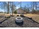 Outdoor fire pit surrounded by mature trees and mulch, creating a cozy entertainment space at 1401 Rainey Rd, Temple, GA 30179