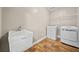 Well-equipped laundry room with modern washer, dryer, large sink, and durable laminate flooring at 1401 Rainey Rd, Temple, GA 30179