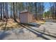Exterior view of a shed next to a driveway surrounded by mature trees at 1401 Rainey Rd, Temple, GA 30179