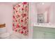 Colorful bathroom with a floral shower curtain and mint green vanity at 1225 W Wesley Nw Rd, Atlanta, GA 30327