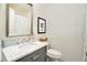 Updated bathroom with a marble countertop, gray vanity, and stylish mirror at 1225 W Wesley Nw Rd, Atlanta, GA 30327