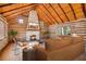 Inviting living room featuring log walls, stone fireplace, and wood ceiling, creating a cozy atmosphere at 1225 W Wesley Nw Rd, Atlanta, GA 30327