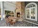 Covered patio featuring a stone fireplace, outdoor dining area and stone tile floors at 1225 W Wesley Nw Rd, Atlanta, GA 30327