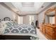 Bedroom with light-colored walls, soft carpet, tray ceilings, and a patterned bedspread at 1370 Wheatfield Dr, Lawrenceville, GA 30043