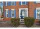 Close-up of a brick home's front entrance featuring a decorative door, sidelights, and manicured bushes at 1370 Wheatfield Dr, Lawrenceville, GA 30043