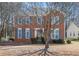 Charming two-story brick home with blue shutters and a well-maintained front yard surrounded by mature trees at 1370 Wheatfield Dr, Lawrenceville, GA 30043