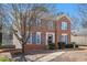 Attractive brick home with blue shutters, complemented by a mature tree and manicured landscaping at 1370 Wheatfield Dr, Lawrenceville, GA 30043