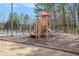 A colorful, wooden playground is nestled in a wood-chip area of the community near the pool and tennis courts at 1370 Wheatfield Dr, Lawrenceville, GA 30043