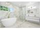 Bright, marble-accented bathroom featuring a modern tub, glass shower and double vanity at 1650 Eastport Se Ter, Atlanta, GA 30317