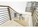 Modern staircase with wood and metal railing, open to the kitchen downstairs at 1650 Eastport Se Ter, Atlanta, GA 30317