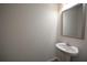 Bathroom with pedestal sink, mirror, white walls, and tile floor at 2453 Osceola Rd, Lithonia, GA 30058