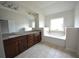 Bathroom featuring double vanity with granite countertops, tub, and tile flooring at 2453 Osceola Rd, Lithonia, GA 30058