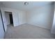 A roomy bedroom with neutral carpet and white walls, with a door leading to another room at 2453 Osceola Rd, Lithonia, GA 30058