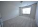 Bright bedroom features a large window with blinds and neutral carpeting at 2453 Osceola Rd, Lithonia, GA 30058