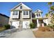 Inviting two-story home with a two-car garage, manicured shrubs, and neutral siding under a clear sky at 2453 Osceola Rd, Lithonia, GA 30058