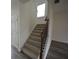 Carpeted stairs with dark wood railing, leading to the upper level at 2453 Osceola Rd, Lithonia, GA 30058