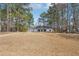 Charming one-story home featuring a manicured lawn and mature trees around the property at 489 Natasha Dr, Auburn, GA 30011