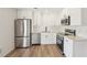 Beautiful kitchen with stainless steel appliances, white cabinetry, and wood-look vinyl flooring at 489 Natasha Dr, Auburn, GA 30011