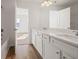 Primary bathroom with double vanity, white cabinets, quartz countertop, and natural light at 1269 Pj East Rd, Covington, GA 30014