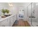 A bright bathroom featuring double vanity, white cabinets, quartz countertops and a glass door shower at 1269 Pj East Rd, Covington, GA 30014