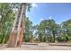 Unique stone and wood entrance structure amidst lush greenery and mature trees, creating a serene setting at 1269 Pj East Rd, Covington, GA 30014