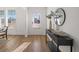 Bright entryway featuring light wood floors, wainscoting, and a stylish console table with a round mirror at 1269 Pj East Rd, Covington, GA 30014