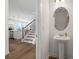 Stylish powder room featuring a pedestal sink, oval mirror, and wood-look flooring at 1269 Pj East Rd, Covington, GA 30014