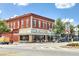 Exterior view of a brick building housing businesses with large windows, street parking, and clear signage at 1269 Pj East Rd, Covington, GA 30014