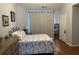 Cozy bedroom with patterned bedding, wood-look floors, and bright natural light at 134 Rose Cottage Ln, Woodstock, GA 30189