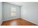 Bedroom featuring light blue walls and wood flooring, with a window at 134 Rose Cottage Ln, Woodstock, GA 30189