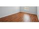 This bedroom has wood-style flooring and a sunlit window with mini-blinds at 134 Rose Cottage Ln, Woodstock, GA 30189