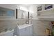 Bathroom with white vanity, mirror, and shiplap wall, offering a clean and stylish design at 3948 Lake Carlton Road S Rd, Loganville, GA 30052