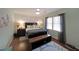 Bedroom with a dark wood bed frame and accents, complimented by soft, natural light from the window at 3948 Lake Carlton Road S Rd, Loganville, GA 30052