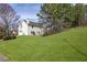 Expansive backyard with well-manicured lawn, complemented by mature trees and the home's facade at 494 Martin Forest Ln, Lawrenceville, GA 30045