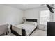 Cozy bedroom with a black bed, a window, and carpet floors at 494 Martin Forest Ln, Lawrenceville, GA 30045