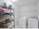 Functional laundry room featuring a washer, dryer, and wire shelving for organized storage at 494 Martin Forest Ln, Lawrenceville, GA 30045