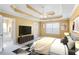 Staged main bedroom with tray ceiling, ensuite bathroom, and TV at 494 Martin Forest Ln, Lawrenceville, GA 30045