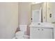 Clean powder room featuring a toilet, sink, vanity, and wall mirror at 494 Martin Forest Ln, Lawrenceville, GA 30045