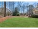 Expansive lawn with a deck and a blend of open space and trees, perfect for outdoor activities at 7270 Sheffield Pl, Cumming, GA 30040